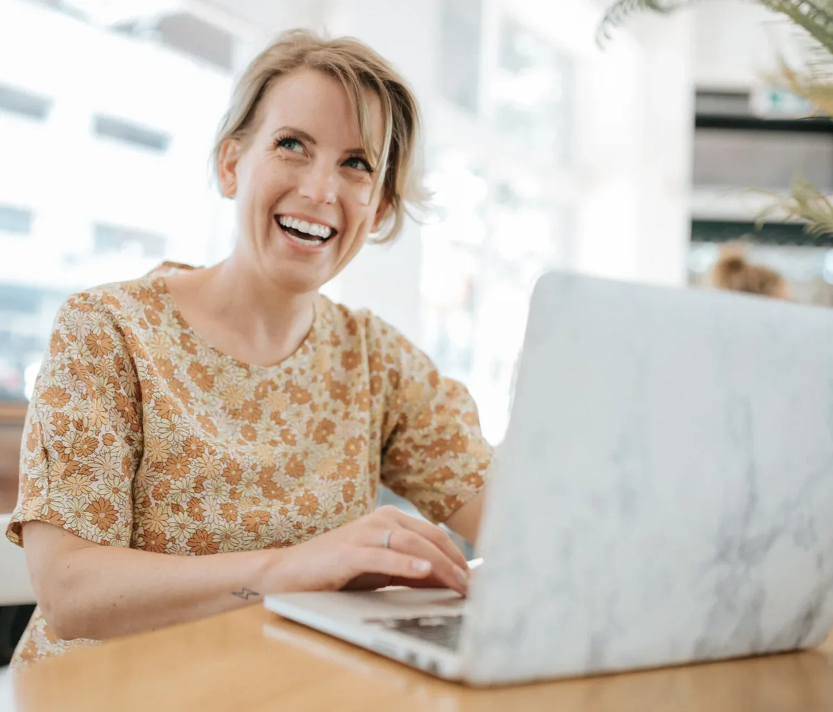 Amanda Leier, founder of Dawn Creative, laughing while working at her laptop